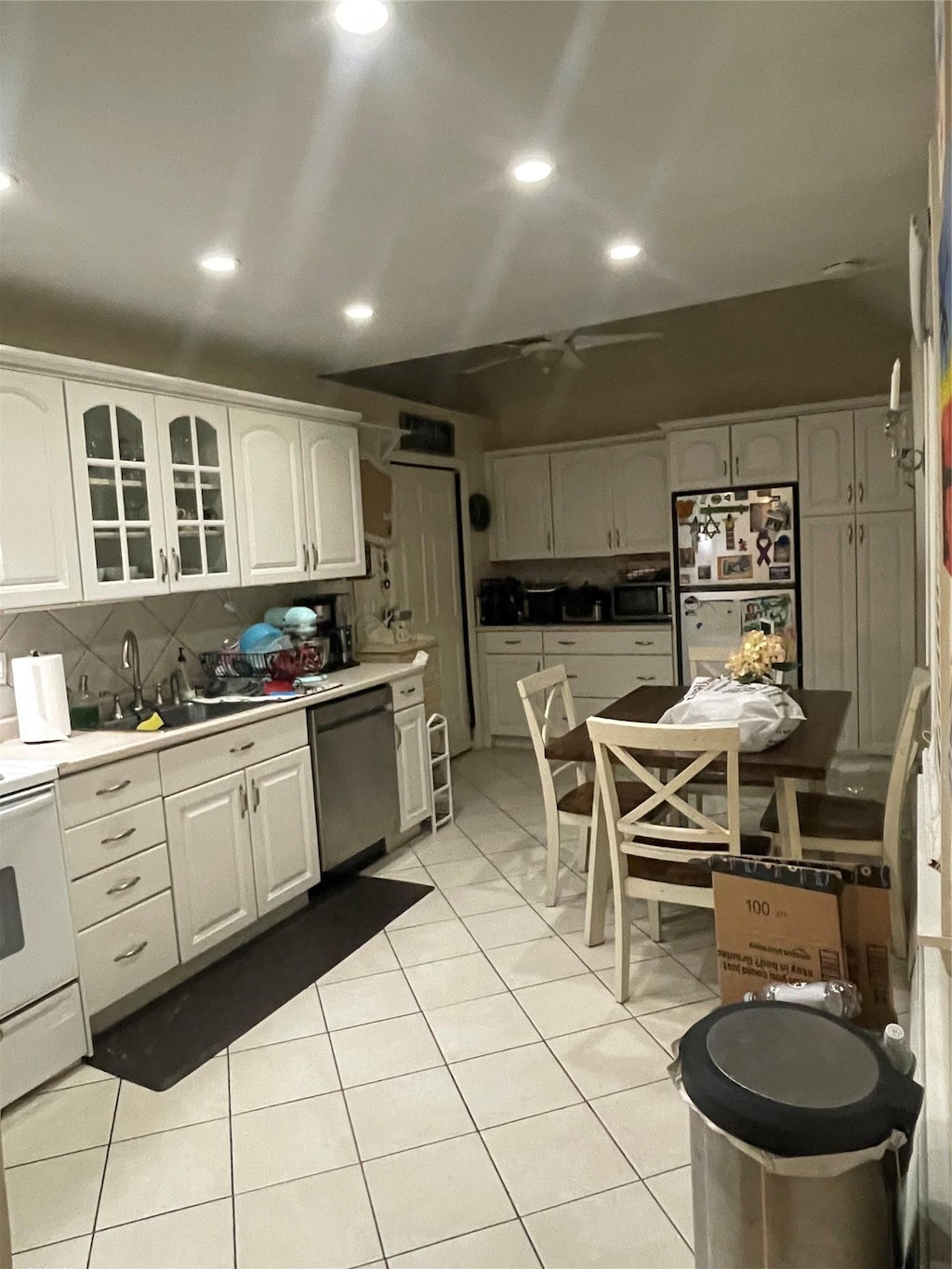 kitchen featuring light tile patterned floors, sink, white cabinetry, fridge, and stainless steel dishwasher