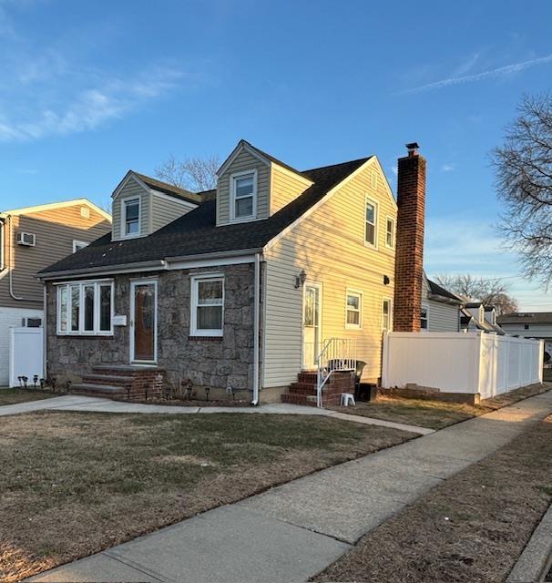 new england style home featuring a front lawn