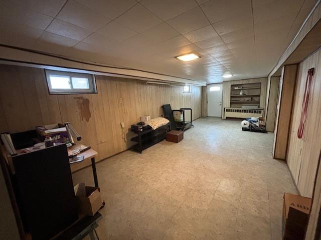 basement with radiator heating unit and wooden walls