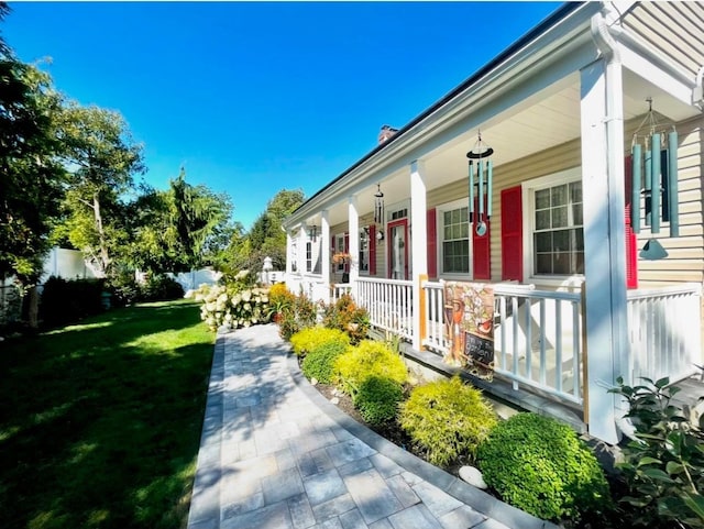 view of side of property featuring a yard and covered porch