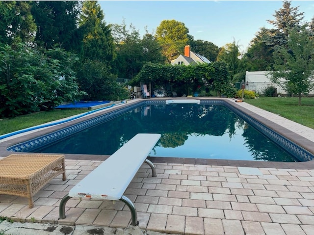 view of pool featuring a yard and a diving board