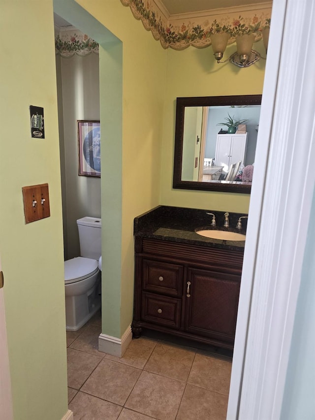 bathroom featuring tile patterned flooring, baseboards, vanity, and toilet