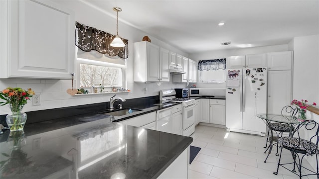 kitchen featuring white cabinetry, sink, white appliances, and a healthy amount of sunlight