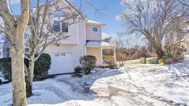 view of snow covered exterior with a garage and a porch