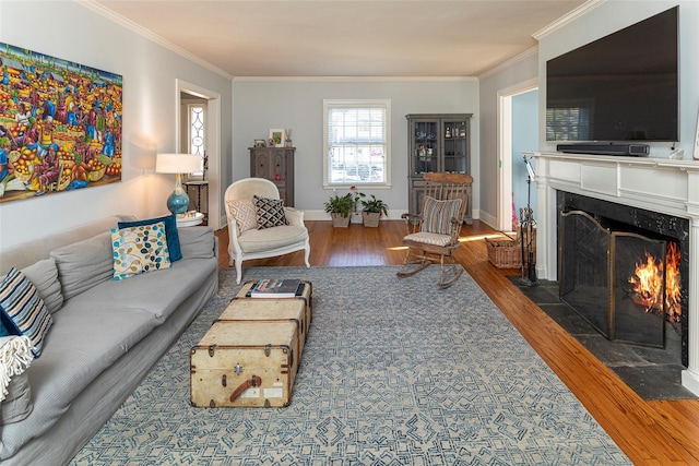 living room featuring wood finished floors, crown molding, baseboards, and a premium fireplace