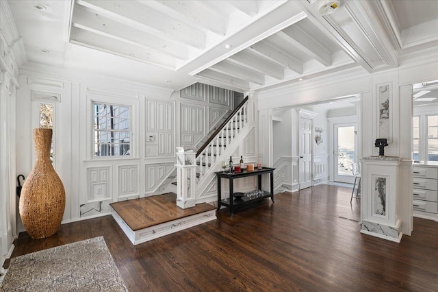 entrance foyer featuring beam ceiling, dark wood-type flooring, and plenty of natural light