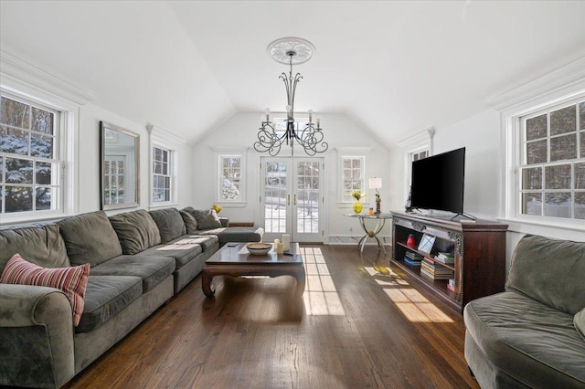 living room featuring vaulted ceiling, a chandelier, dark hardwood / wood-style flooring, and french doors