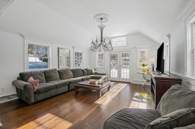 living room featuring a notable chandelier, dark hardwood / wood-style floors, vaulted ceiling, and french doors