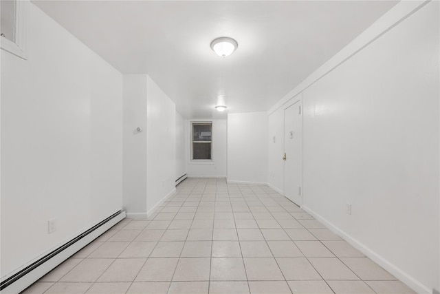 spare room featuring light tile patterned flooring and baseboard heating