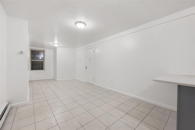 tiled spare room with a baseboard heating unit