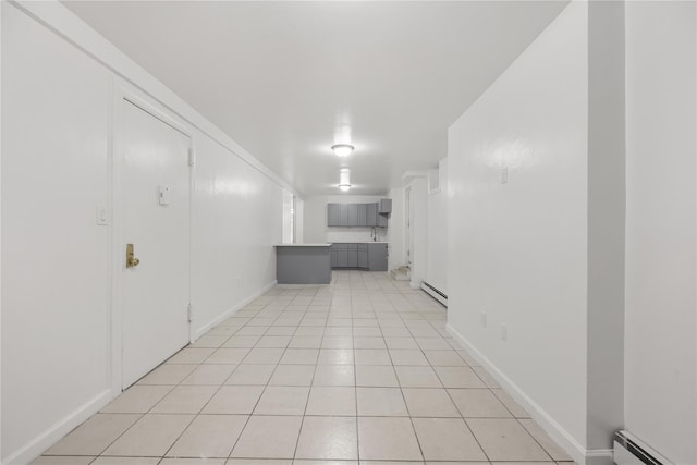 interior space with a baseboard heating unit and light tile patterned floors