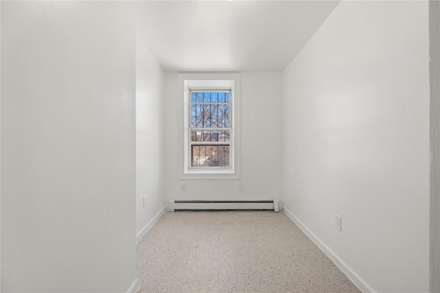 unfurnished room with a baseboard heating unit