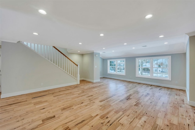 unfurnished living room with ornamental molding and light hardwood / wood-style flooring