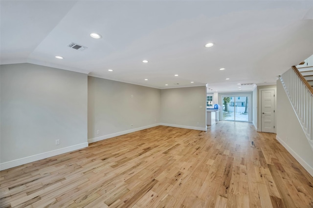 spare room featuring lofted ceiling and light wood-type flooring