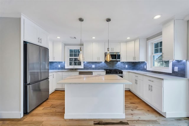 kitchen with white cabinetry, pendant lighting, and appliances with stainless steel finishes