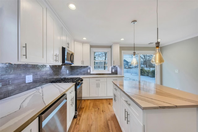 kitchen with white cabinetry, stainless steel appliances, light stone countertops, and pendant lighting