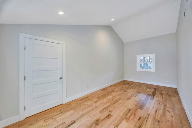 additional living space featuring vaulted ceiling and light hardwood / wood-style flooring