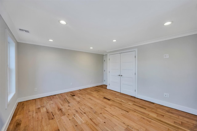 unfurnished bedroom with a closet, ornamental molding, and light hardwood / wood-style flooring