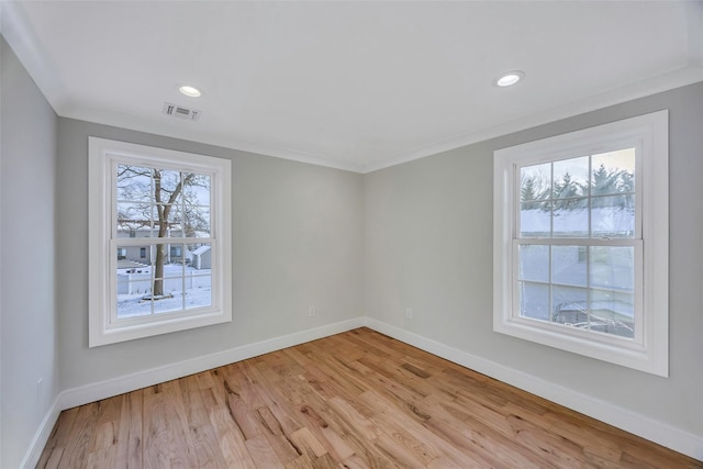 spare room featuring light hardwood / wood-style flooring and ornamental molding