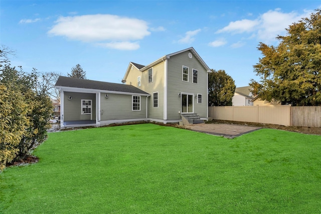 rear view of house with a patio area and a lawn