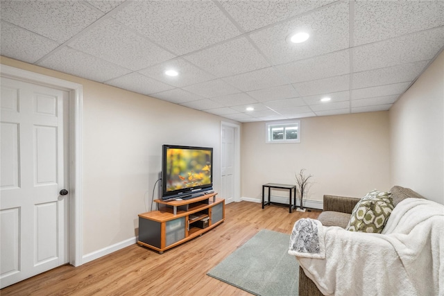 living room with a paneled ceiling and wood-type flooring