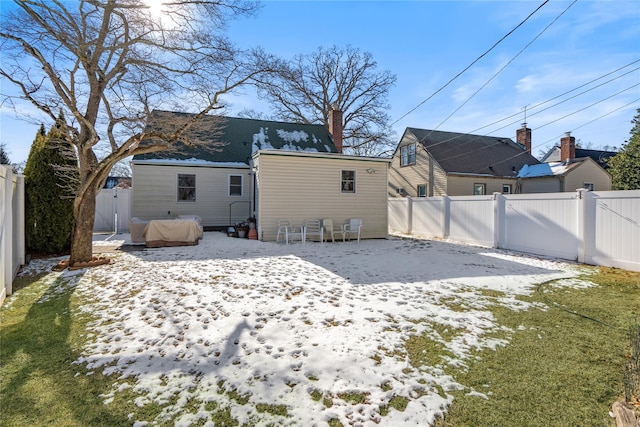 view of snow covered rear of property