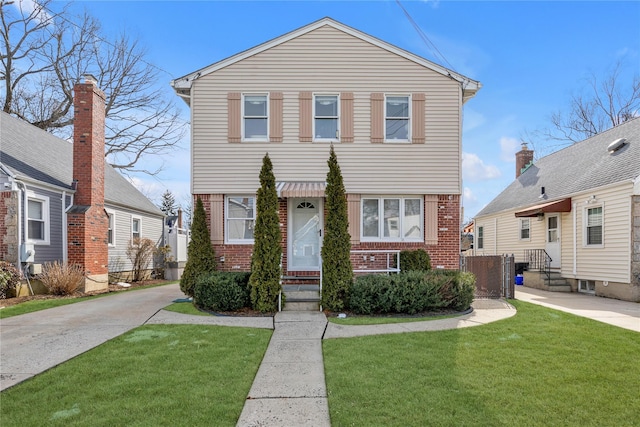 view of front of property featuring a front yard and brick siding