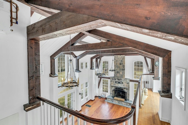 living room featuring lofted ceiling with beams, wood-type flooring, and a fireplace