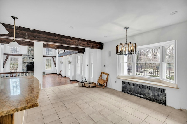 unfurnished dining area with light tile patterned flooring, radiator heating unit, a notable chandelier, and a fireplace