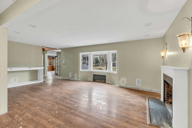 unfurnished living room with radiator and hardwood / wood-style floors