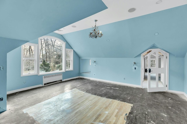 additional living space featuring lofted ceiling, radiator heating unit, and a chandelier