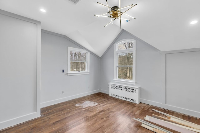 additional living space featuring lofted ceiling, radiator heating unit, and dark hardwood / wood-style flooring