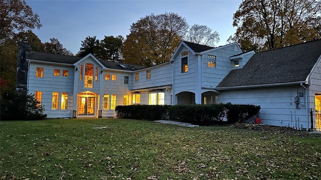 rear view of property featuring a lawn