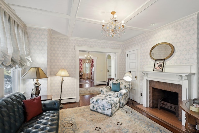 living room featuring baseboard heating, dark hardwood / wood-style flooring, a brick fireplace, and a notable chandelier