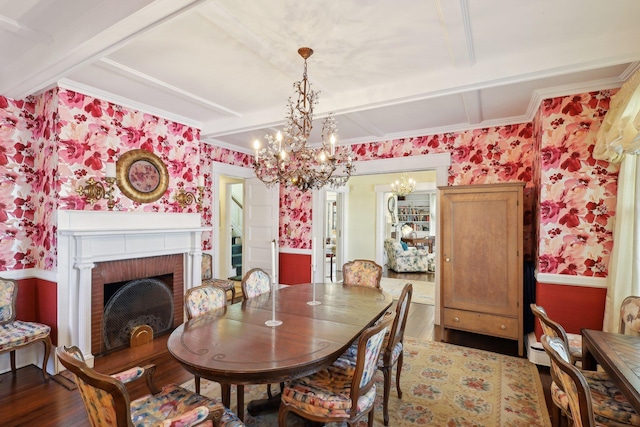 dining room featuring dark hardwood / wood-style floors, beamed ceiling, ornamental molding, a notable chandelier, and a brick fireplace