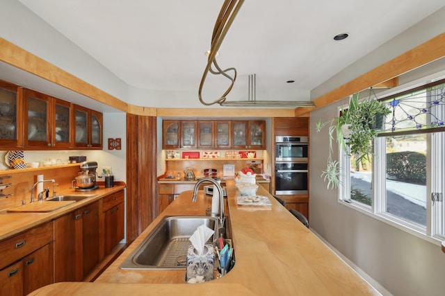 kitchen featuring stainless steel double oven and sink