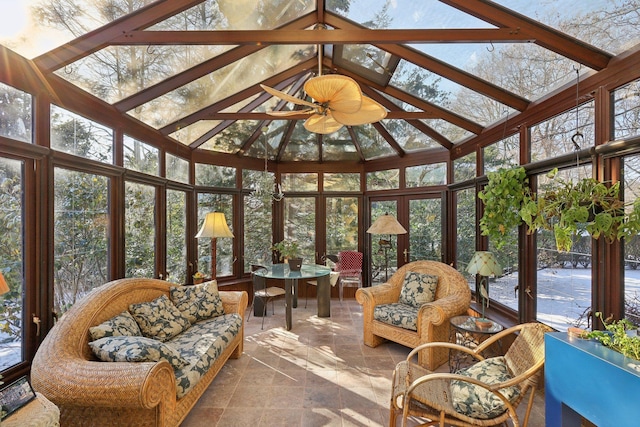 sunroom / solarium with ceiling fan, a healthy amount of sunlight, and vaulted ceiling with beams