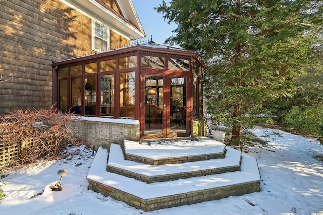 snow covered property entrance with french doors