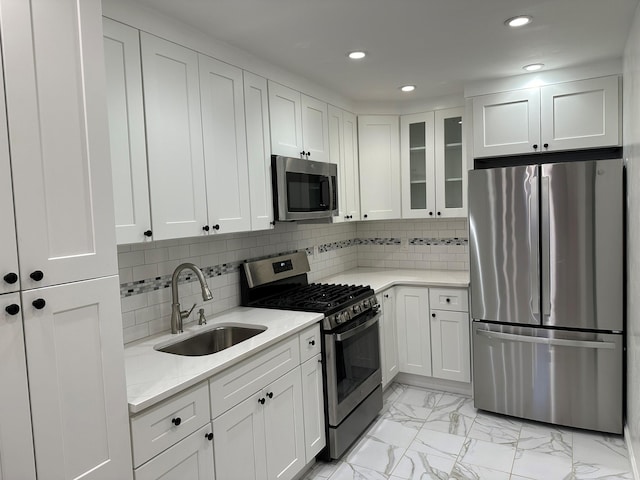 kitchen featuring light stone countertops, white cabinetry, appliances with stainless steel finishes, and sink