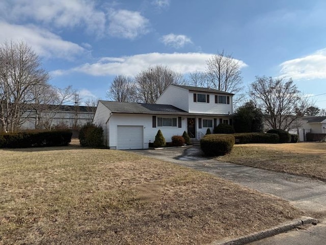 front of property with a garage and a front lawn