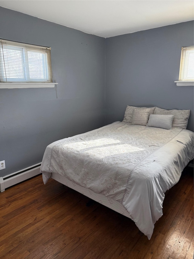 bedroom featuring a baseboard heating unit and dark hardwood / wood-style floors