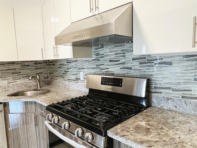 kitchen featuring appliances with stainless steel finishes, sink, white cabinets, and light stone counters