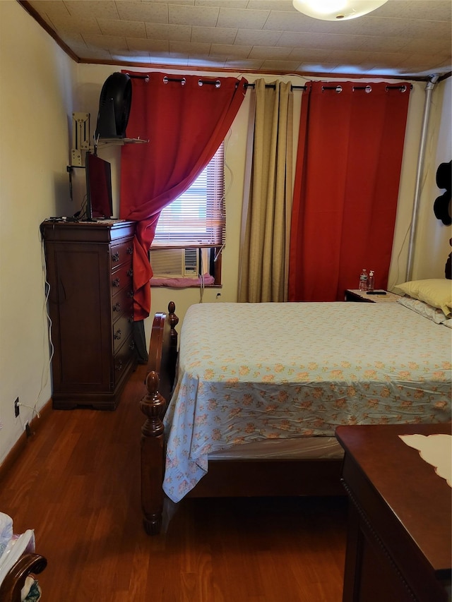 bedroom featuring crown molding and dark hardwood / wood-style flooring