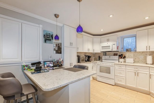 kitchen with decorative light fixtures, white cabinetry, a breakfast bar area, light stone counters, and white appliances