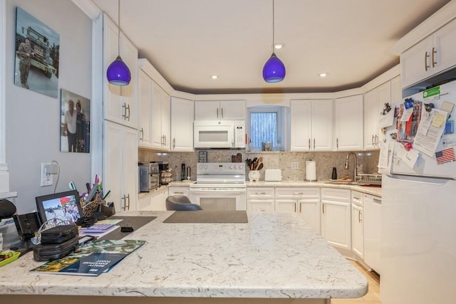 kitchen with sink, white appliances, decorative light fixtures, and white cabinets