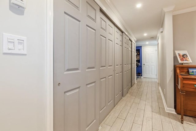 corridor featuring ornamental molding and light hardwood / wood-style flooring