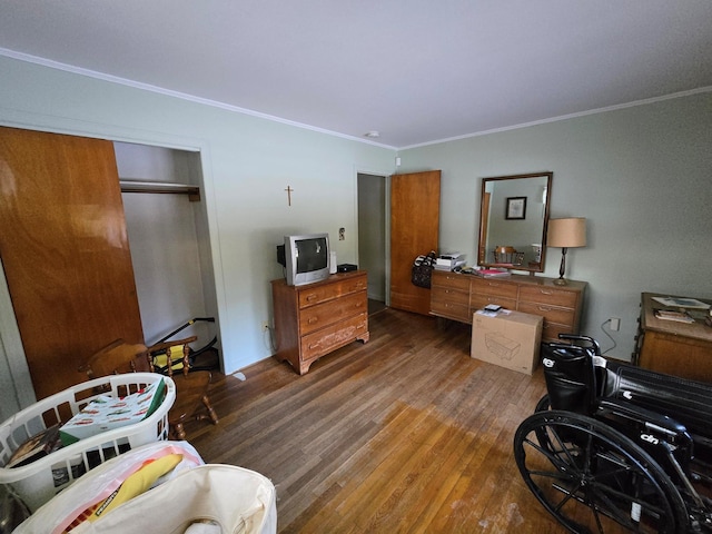 bedroom featuring dark wood-type flooring, ornamental molding, and a closet