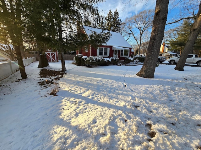 yard layered in snow with a storage shed