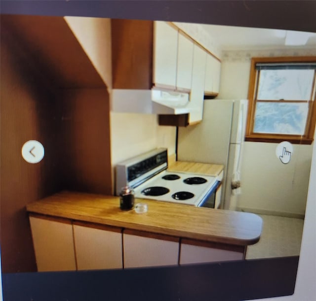 kitchen with electric range, wooden counters, and white cabinets