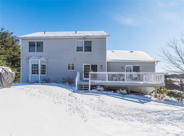 snow covered rear of property featuring a wooden deck